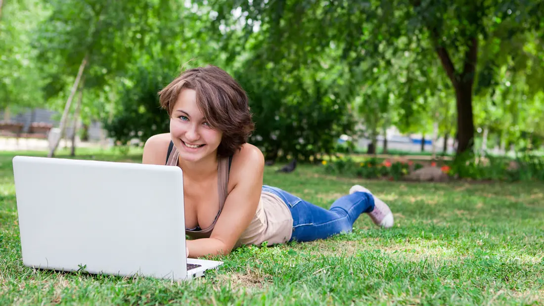 A tutor smiling while teaching an online lesson from home